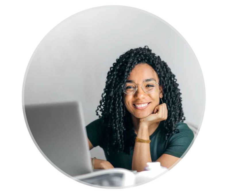smiling young Black woman in front of computer