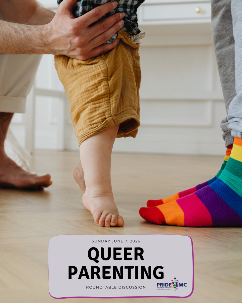 Two adults stand on either side of a toddler, holding the child’s hands as they learn to walk. One adult is wearing rainbow-striped socks.